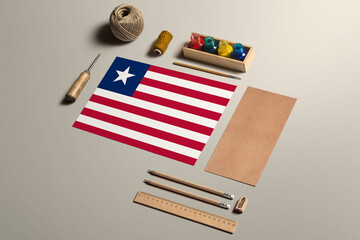 Fototapeta na wymiar Liberia calligraphy concept, accessories and tools for beautiful handwriting, pencils, pens, ink, brush, craft paper and cardboard crafting on wooden table.