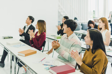 Asians attend seminars and listen to lectures from speakers in the training room.  Some people raised their hands to ask the narrator. And applauded when the speaker finished speaking.