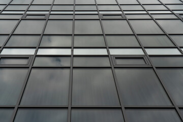 The glazed facade of the building is made of dark glass.