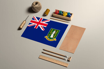 Fototapeta na wymiar British Virgin Islands calligraphy concept, accessories and tools for beautiful handwriting, pencils, pens, ink, brush, craft paper and cardboard crafting on wooden table.