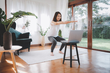 woman learned online workout excercise class at home from laptop