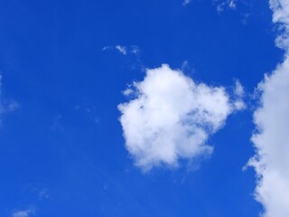 Fototapeta na wymiar white fluffy clouds on bright blue sky background