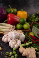 Chilli, lime, basil, kaffir lime leaves, eggplant, ginger, spring onions, bell peppers, garlic, lemongrass, put together for cooking.