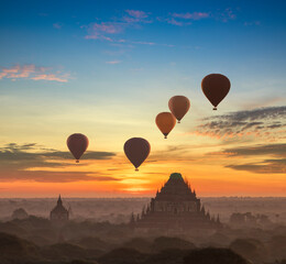 Hot air balloon over plain of Bagan in misty morning, Myanmar at sunrise