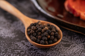 Pepper seeds in a wooden spoon.