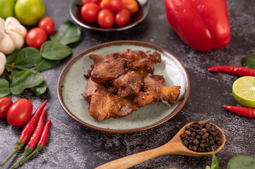 Pork cutlet in a white plate on black cement.