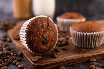 Banana cupcakes that are placed on a wooden plate with coffee grains.