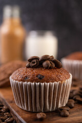Banana cupcakes that are placed on a wooden plate with coffee grains.