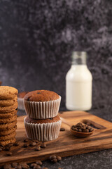 Banana cupcakes that are placed on a wooden plate with coffee grains.