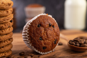Banana cupcakes that are placed on a wooden plate with coffee grains.