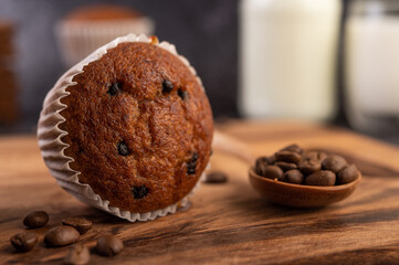 Banana cupcakes that are placed on a wooden plate with coffee grains.
