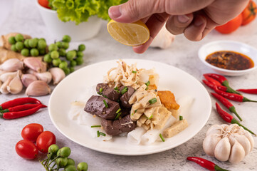 Large noodle noodles with pork blood sausage, crispy pork slices, and sliced ​​onions in a...