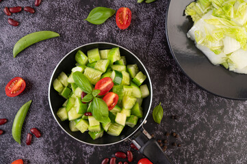 Cucumber stir-fried with tomatoes and red beans in a frying pan.