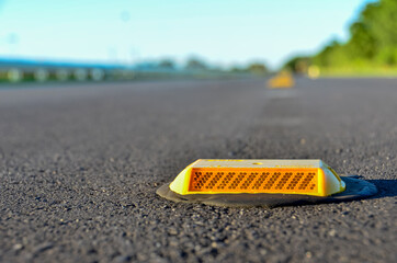 Yellow raised reflective marker on road