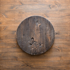 round wooden plate on old wooden background