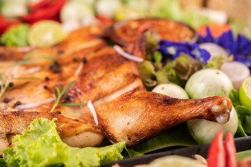 Grilled chicken on the plate with chili Garlic and sprinkled with pepper seeds.