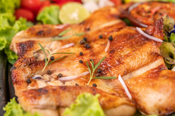 Grilled chicken on the plate with chili Garlic and sprinkled with pepper seeds.