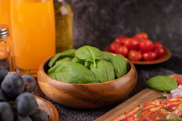 Thyme and tomatoes in a wooden cup with garlic on a wooden chopping board.