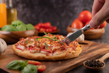 pizza placed on a wooden plate.