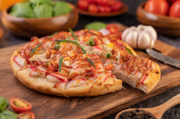 pizza placed on a wooden plate.