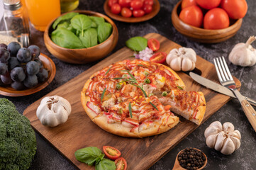 pizza placed on a wooden plate.