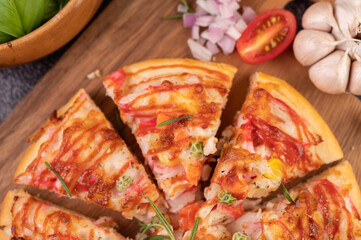pizza placed on a wooden plate.
