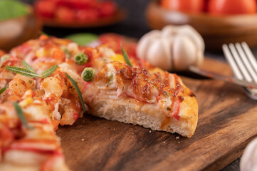 pizza placed on a wooden plate.