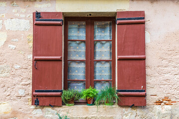 Fototapeta na wymiar A brown shuttered window on a house in the town of Hautefort.