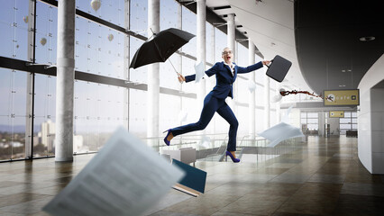 Young businesswoman walking with umbrella