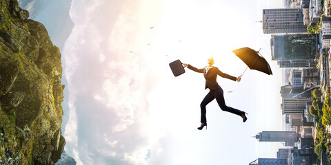 Young businesswoman walking with umbrella
