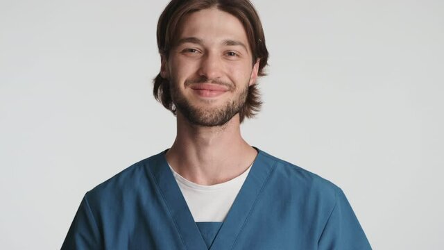 Portrait of young bearded male doctor happily showing thanks expression on camera isolated