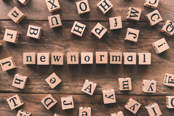 Square wooden blocks arranged with "new normal" letters arranged in wooden blocks, other letters, concept New lifestyle adjustment Due to the COVID-19 virus outbreak