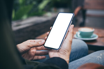 cell phone mockup image blank white screen.woman hand holding texting using mobile on desk at coffee shop.background empty space for advertise.work people contact marketing business,technology