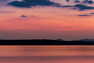 Fototapeta na wymiar View of the opposite shore of the lake at dusk.