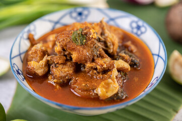 Sweet pork in a ceramic cup placed on a banana leaf.