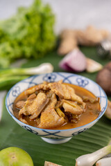 Red curry with pork belly and put morning glory in a ceramic cup.