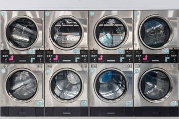 Close-Up multiple Industrial Washing Machines in Luadry Shop, Washing with hot and cold water keeps...
