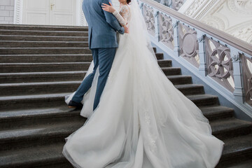Plakat groom and bride in a wedding dress on the big stairs
