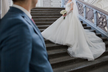 groom and bride in a wedding dress on the big stairs
