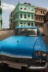 Cuban car with a green building in the background in the city of la Havana, Cuba