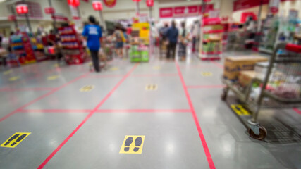 Yellow marker strips of a shopping centre, showing customers in the queue the correct distance to avoid infection with the Corona virus