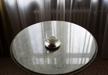 cup of morning coffee on a round marble table with different items