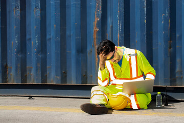 Engineers wear uniform reflective with sunglasses feeling stressed after receiving problematic e-mail on a laptop over blue containers box from cargo freight ship in warehouse background. 