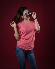 Front view pink t-shirt Closeup on female body, woman girl in empty pink t-shirt isolated on red background. Design woman t-shirt template and mockup for print.