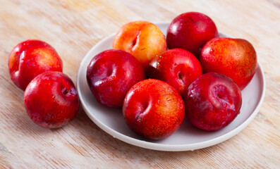 Tasty ripe red plum on a wooden surface. Healthy fruits