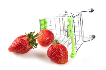 Mini supermarket trolley with scattered strawberries