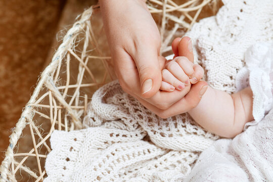 Newborn baby hand in mother hand. Happy mother holding hand of her newborn children. Mom and her child. Happy Family concept. Beautiful conceptual image of maternity