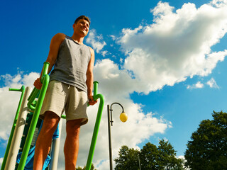Man flexing arms in outdoor gym