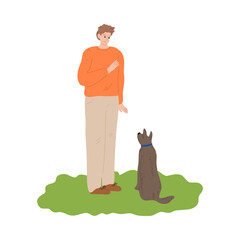 Boy training his dog by showing hand command outdoor during walk