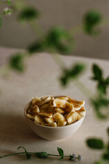 Pretty small ivory bowl with sliced banana on table in the kitchen with mint leaves decoration. Tasty and healthy vegetarian food isolated close up